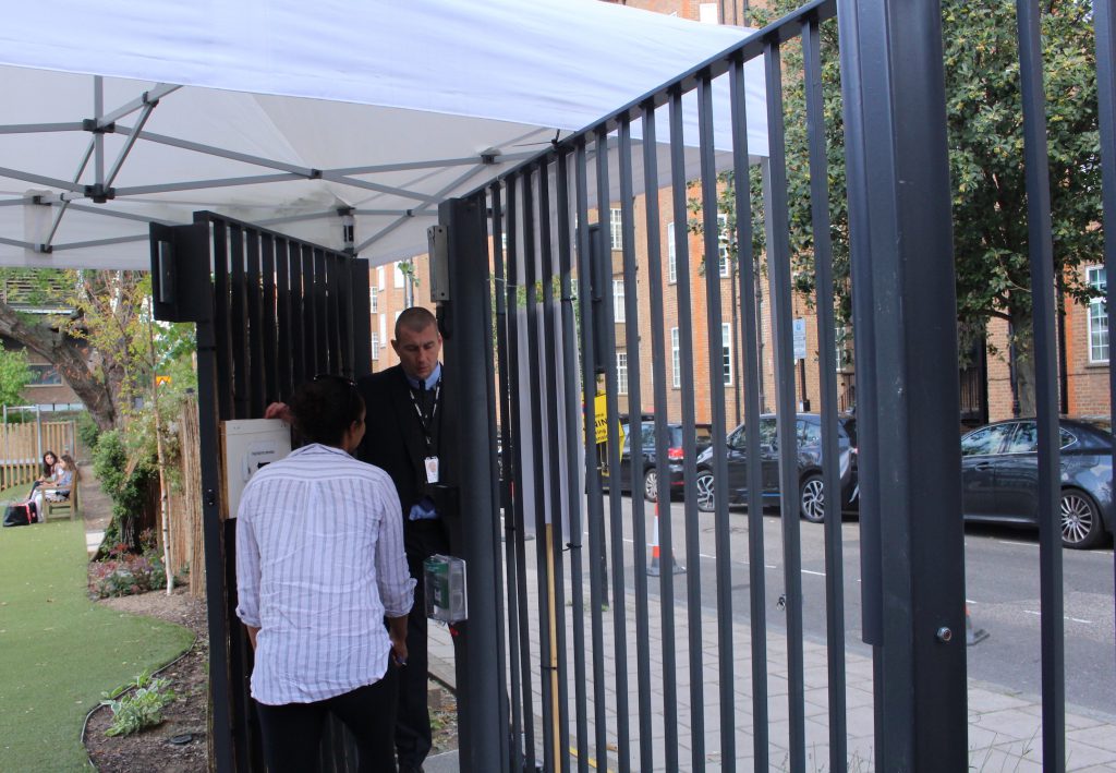 A security guard speaks with a teacher during closed campus on September 10.