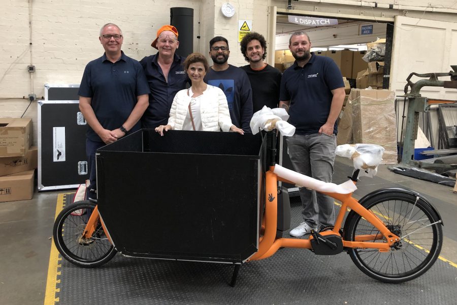 Fareh Asemi (P'11) poses with the assembly team of a prototype of the ecofleet bike. ecofleet is a new carbon neutral delivery company based in London. 