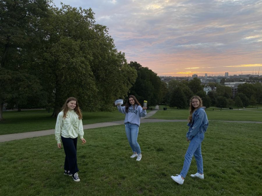 Solenne Jackson (21), Mona Marouf (21) and Eleanor Benton (21) pose two meters apart in front of the sunrise. Grade 12 students gathered at the top of Primrose Hill at 5:45 a.m. to watch the sunrise.