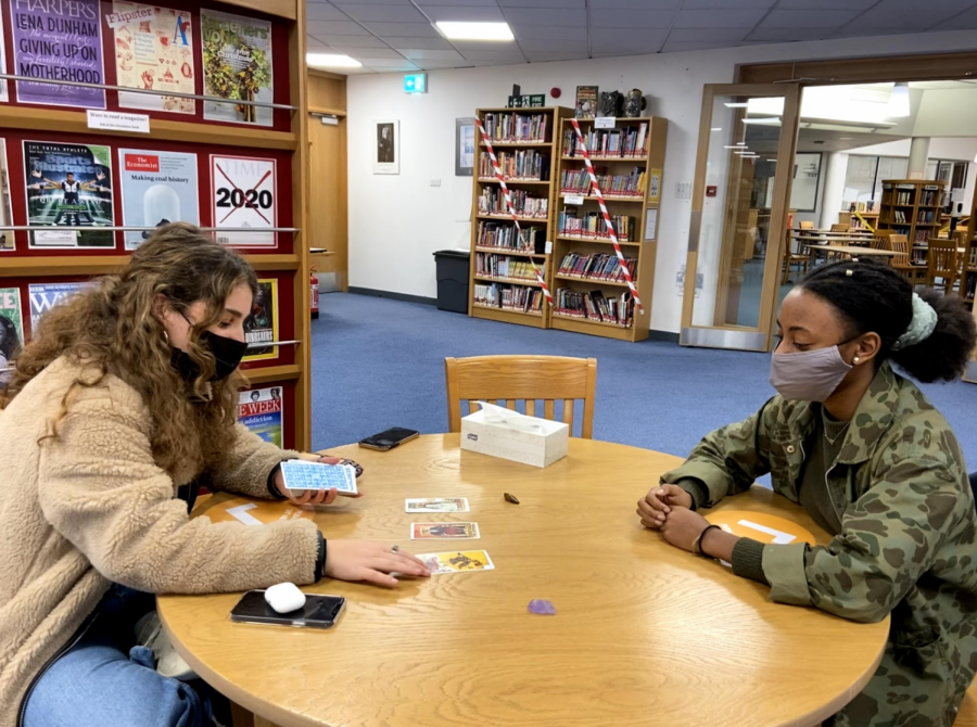 Micaella Lavi (21) gives Olivia Benjamin-MacDonald (21) a tarot reading in the Mellon Library. Lavi began teaching herself how to read tarot in November 2020 after being gifted a pack by a friend.