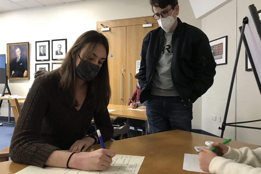 Anna Duffy (’21) works on a freedom charter while Co Workshop Leader Rudi Stern (’22) reads it in the “Freedom – A Right or a Privilege?” workshop March 23. Co Workshop Leader Ily Brigui (’22) said this activity led to a discussion on “balanc[ing] consequences of a free society” with “freedom itself.”