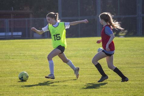 Olivia Lang (’22) dribbles away from Casey Johnson (’23) March 29 and looks to pass to a teammate.