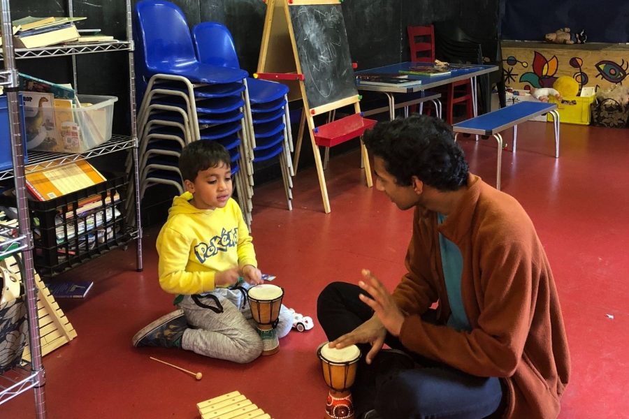 Rohan Prasad (’18) plays with a child at St. Johns Wood Adventure Playground in March 2018. This spring, the same community partnership resumed in person.