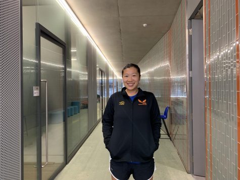 MS/HS PE Teacher Bonnie Lam smiles in the hallway near the pool. Lam found a passion for teaching PE after growing up playing sports and seeing how the skills she learned could be applied to other facets of life.