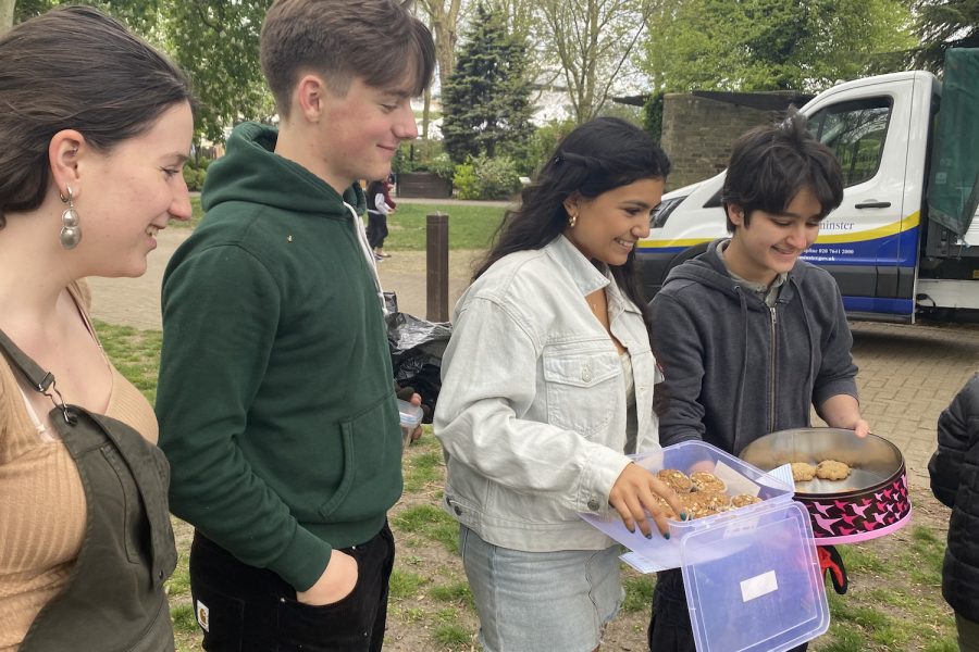 Following a cleanup at the St. Johns Wood Church Grounds, Sustainability Council Co-President Skyler Sweidan (22), SusCo member Dylan Linton (23), SusCo Co-President Victoria Figueroa (22) and SusCo member Suvana Wasu (25) distribute treats. The event between High School and Lower School volunteers took place on Earth Day, April 22.