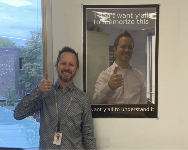 Math Teacher Tony Bracht poses alongside his customized motivational poster. Bracht said one of his favorite components about teaching is watching students grow. “I get to be that part of the journey where students transition from following the leader to being the leader,” Bracht said. “I also get to see students discover their love of math.”