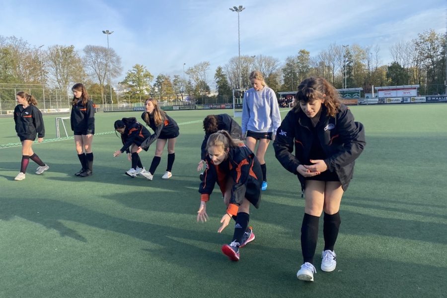Varsity+field+hockey+Co-Captain+Chloe+Howell+%28%E2%80%9923%29+and+defender+Iona+Sweidan+%28%E2%80%9925%29+participate+in+the+team%E2%80%99s+warm-up+before+their+first+game+of+the+competition+against+the+International+School+of+the+Hague.+Before+each+game%2C+the+team+warms+up+with+dynamic+stretches%2C+running+around+the+pitch%2C+passing+in+pairs+and+shooting+with+the+goalie.