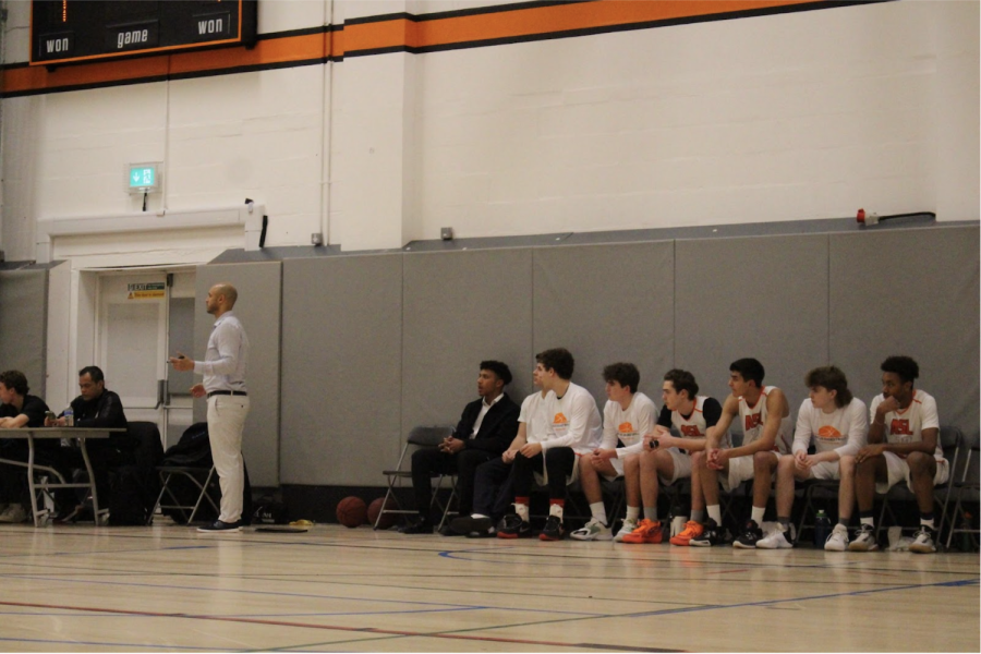 Varsity+boys+basketball+head+coach+Tony+Lazare+stands+on+the+sidelines+during+a+game+against+Norwood+School+Feb.+15.+The+team+won+the+game+58-46.