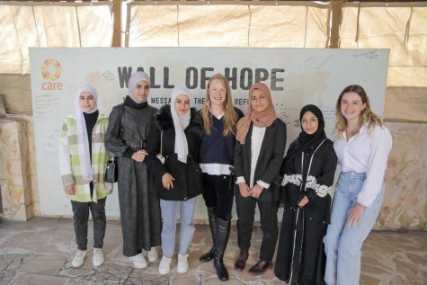 Syrian refugees supported by the CARE program pose in front of the Wall of Hope at the CARE center in Amman, Jordan. After fleeing conflict in Syria, these refugee girls pursue an education after overcoming countless obstacles.