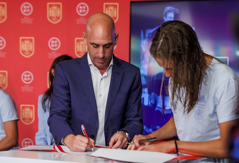 President of the Spanish Football Federation Luis Rubiales signs a contract with a Spanish women’s team player. Rubiales kissed player Jenni Hermoso as the team received their medals Aug. 20. 
