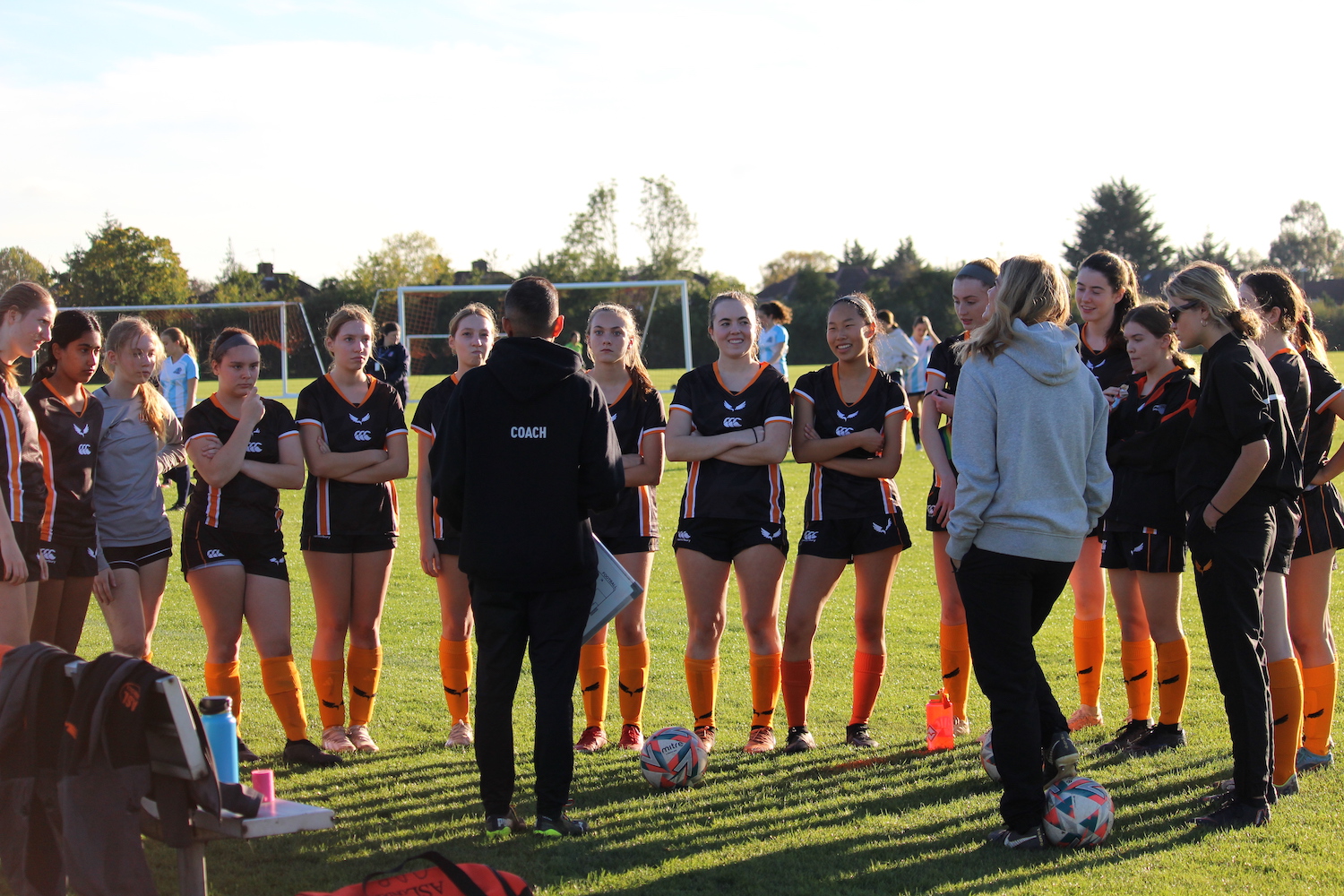 The varsity girls soccer team listens to coach Pranay Dhanani before their game against TASIS at Canons Park Oct. 30. The team won the game 6-2. 