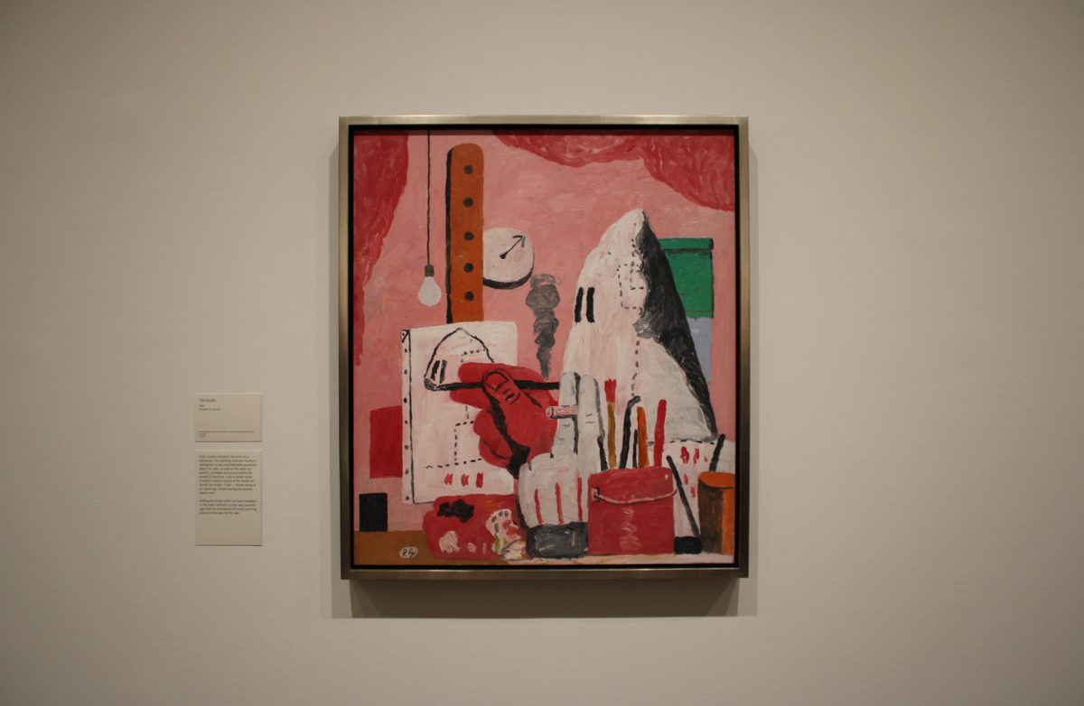 In “The Studio,” created in 1969, Guston presents the artist as a Klansman. Guston was willing to ask the uncomfortable questions, probing themes of evil and accountability, in a greater stride for societal justice. Guston used signature symbols from his life and paintings in this piece, such as a cigarette, clock, lightbulb, window and paintbrushes.