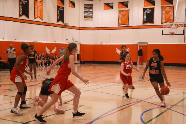 Kaavya Dubey (27) dribbles the ball past the three-point line, getting ahead of her defender. Female athletes require further appreciation in the media and news coverage. 