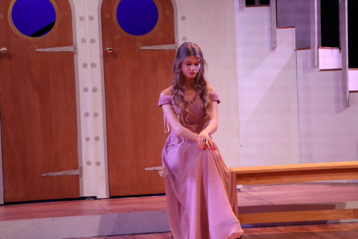 Eleanor Ilyas (’24) bows her head while performing in the High School musical “Anything Goes” Nov. 16, 2023. Ilyas played Hope Harcourt, a debutante who was forced into a marriage but later found love unexpectedly. 