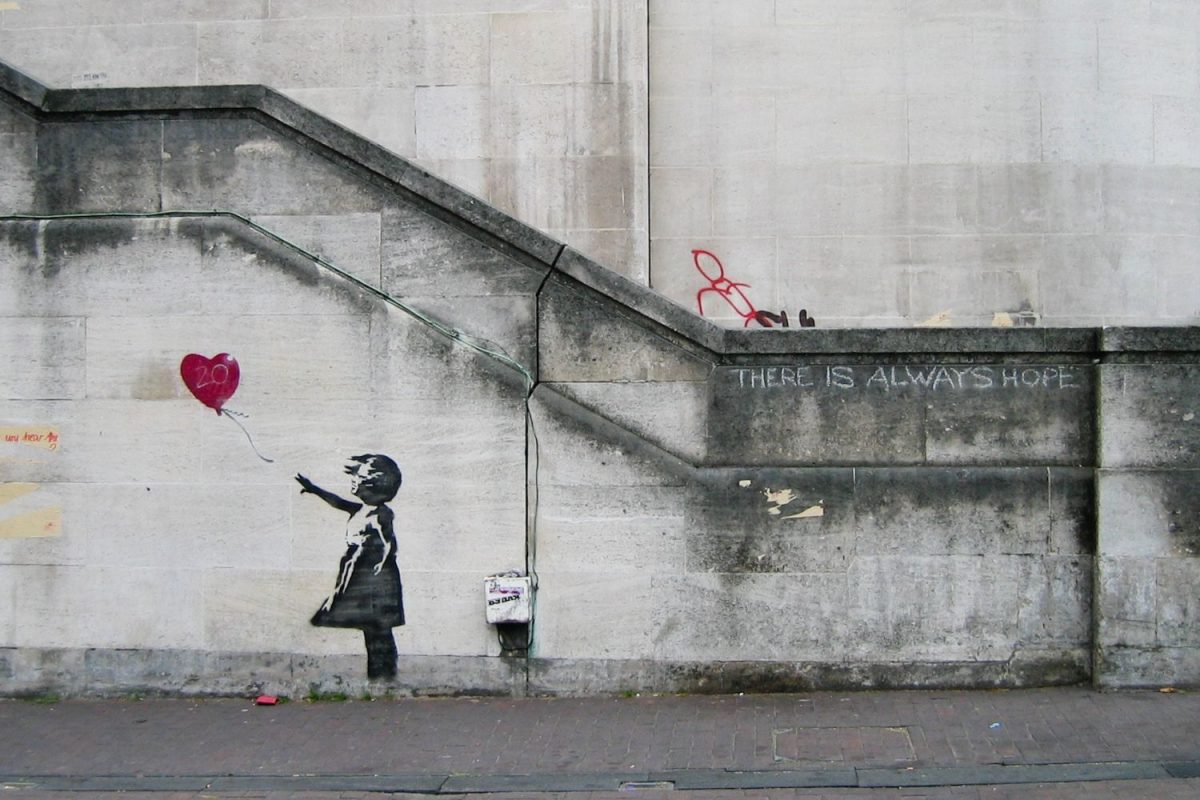 Banksy’s mural titled “Balloon Girl” captures a young girl watching her heart-shaped balloon fly away. The piece was originally created in 2002 and, although it is open to interpretation,  most believe it was created to spread a message of hope and innocence.