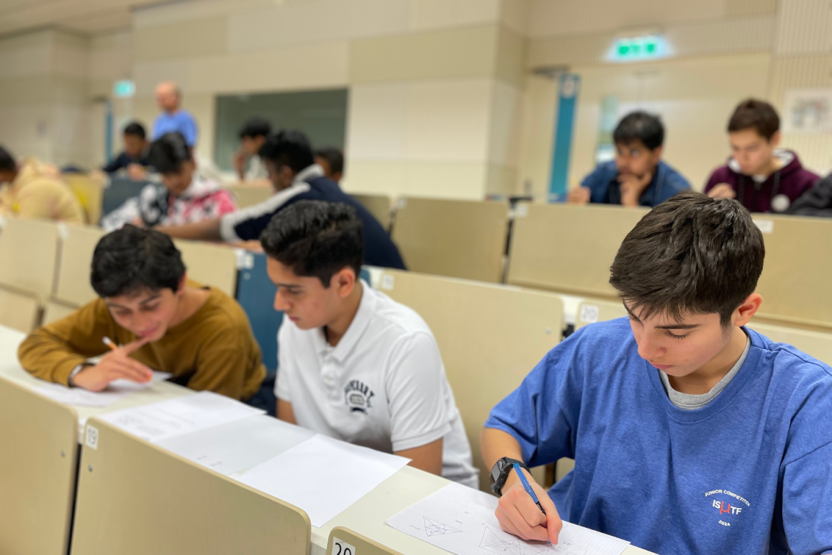 Rian Puri (26), Neel Dandekar (27) and Fede Formenti (’26) work on math problems at the International Schools Mathematics Teacher Foundations Junior competition in Vienna Feb. 24. The three students completed complex problem-solving questions on various tests and activities. Photo courtesy of Mark Basoum.
