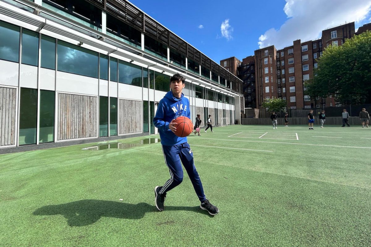 Ethan Rhodes (’25) dribbles a basketball on the school playground. Rhodes played basketball on the JJV team.